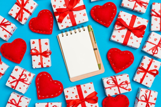 Composizione di San Valentino di quaderno, scatole regalo e cuori di tessuto rosso