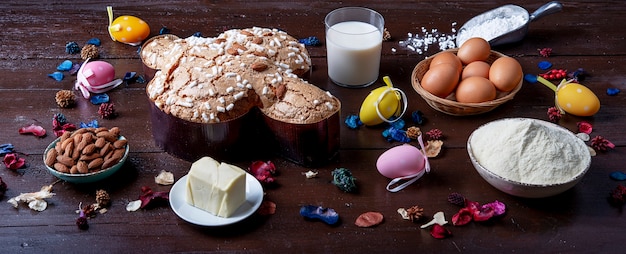 Composizione di un dolce tipico italiano per le feste della Paqua chiamato colomba pasquale, con farina, uova, glassa, frutta candita e mandorle