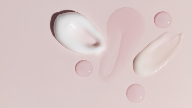 Composizione di varie creme cosmetiche creme siero e lozioni striscio su sfondo rosa