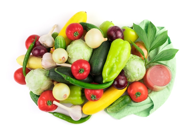 Composizione di verdure fresche mature, un bicchiere di succo di verdura e un ramo verde con gocce d'acqua.