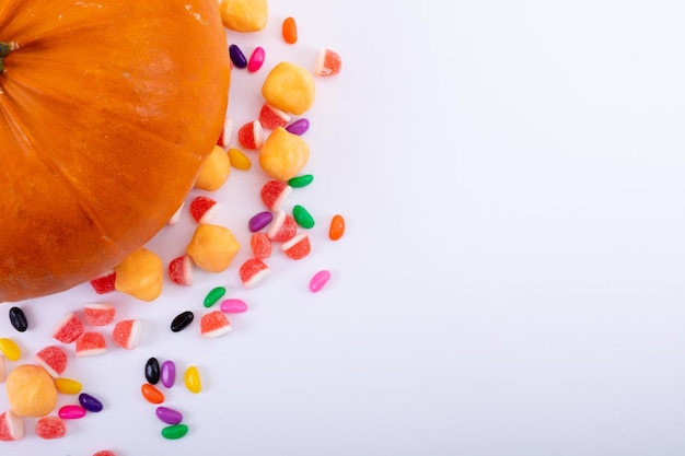 Composizione di zucca di Halloween e dolci trick or treat con spazio di copia su sfondo bianco. tradizione di Halloween e concetto di celebrazione.