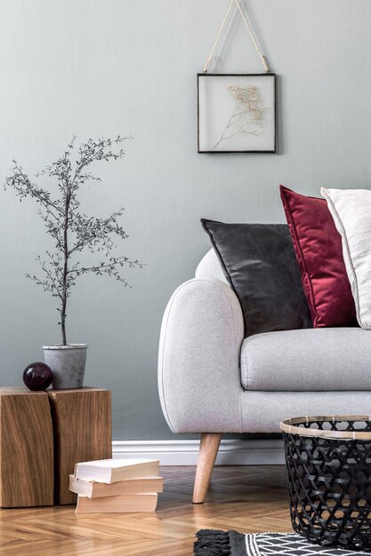 Composizione elegante di dettagli interni accoglienti del soggiorno e cuscini colorati di classe. Parete creativa grigia e pavimento in parquet. Stile scandinavo.