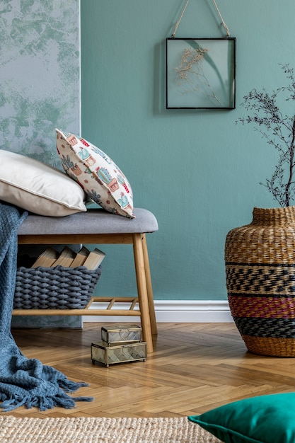 Composizione elegante di dettagli interni accoglienti del soggiorno e cuscini colorati di classe. Parete creativa verde e grigia e pavimento in parquet. Stile scandinavo.