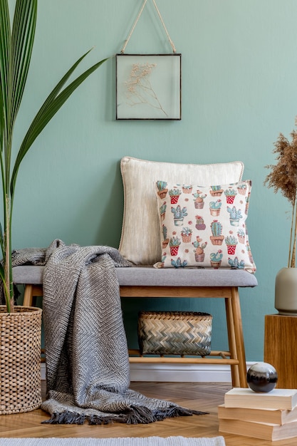 Composizione elegante di dettagli interni accoglienti del soggiorno e cuscini colorati di classe. Parete verde e pavimento in parquet. Stile scandinavo.