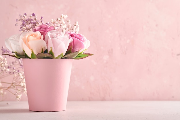 Composizione festiva con bellissimi fiori di rose delicate in scatola rotonda rosa su sfondo rosa chiaro. Cartolina d'auguri di felice festa della mamma. Immagine quadrata.