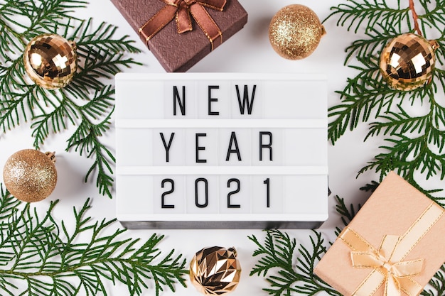 Composizione festiva per il nuovo anno 2021. Scatole regalo e palle di Natale dorate