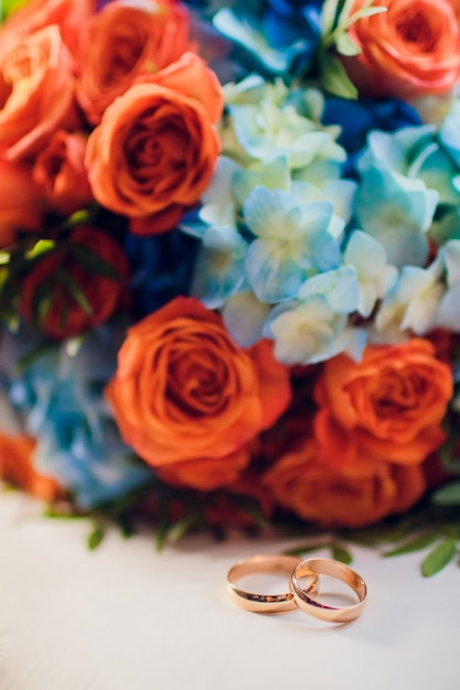 Composizione floreale arancione e blu per un matrimonio: rose arancioni e larkspur blu.