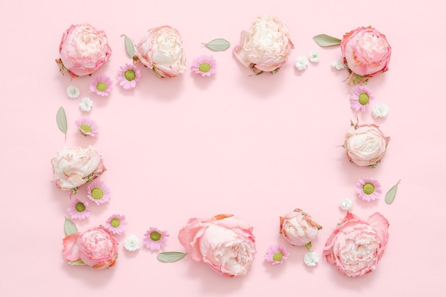 Composizione floreale di saluto Cornice di rose e foglie su sfondo rosa