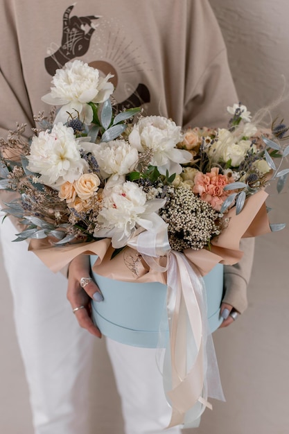 Composizione floreale in una cappelliera di peonie