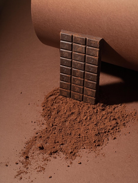 Composizione monocromatica di cioccolato fondente e cacao grattugiato su fondo marrone