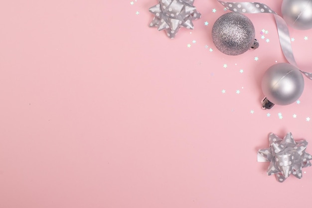 Composizione natalizia albero di Natale giocattoli d'argento e decorazioni natalizie sullo sfondo rosa