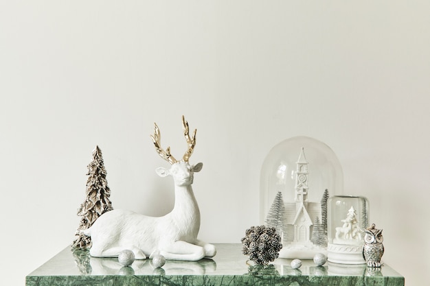 Composizione natalizia con bellissime decorazioni, albero di Natale e ghirlanda, cervi, regali e accessori in un arredamento moderno per la casa. Modello.