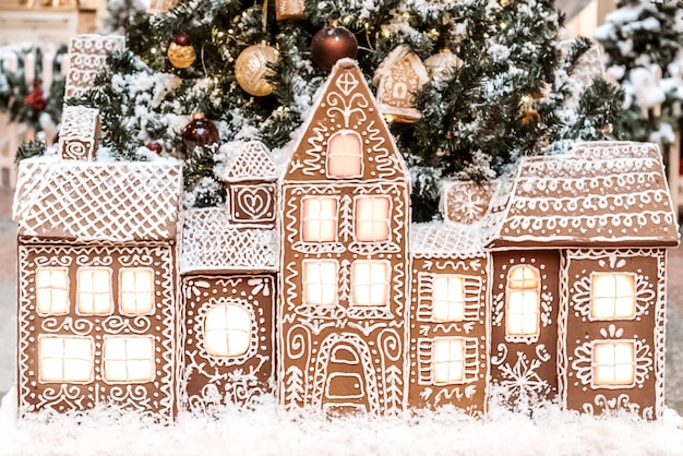Composizione natalizia con case di pan di zenzero in fila sullo sfondo dell'albero di natale