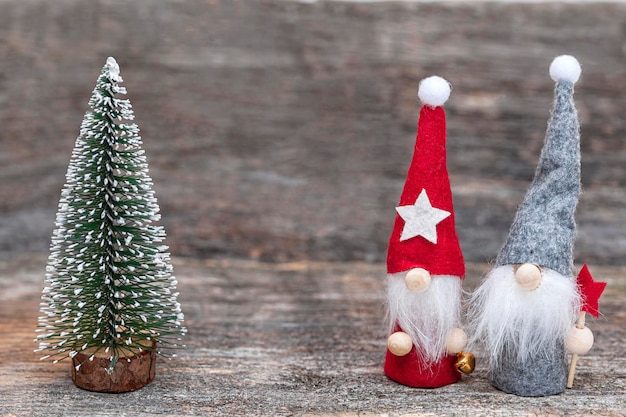 Composizione natalizia con gnomi e albero di Natale su fondo in legno