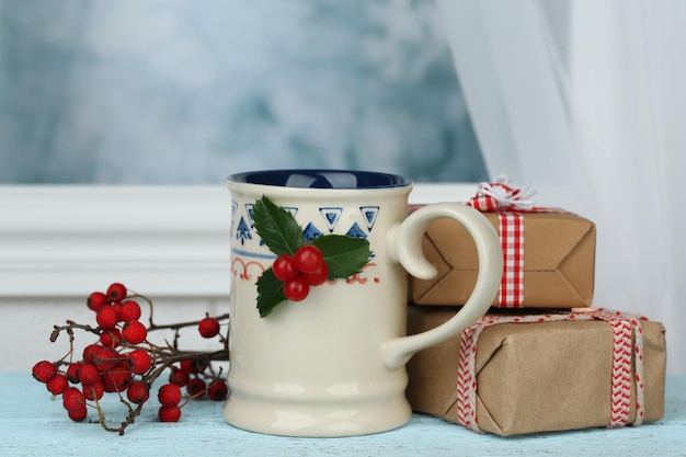 Composizione natalizia con tazza di bevanda calda, su tavola di legno