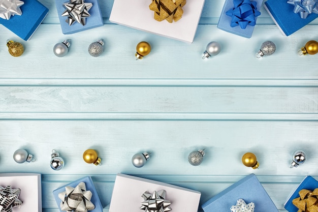 Composizione natalizia, copia spazio. Palle di Natale argento e oro, scatole regalo blu e bianche decorate con fiocchi. Layout festivo.