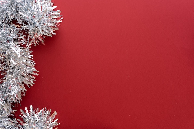 Composizione natalizia Decorazione natalizia orpello bianco su sfondo rosso Spazio piatto vista dall'alto