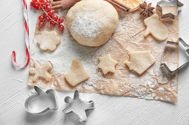 Composizione natalizia di pasta cruda e biscotti su tavola di legno