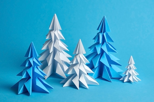 Composizione negli alberi di Natale di origami di carta bianca e blu