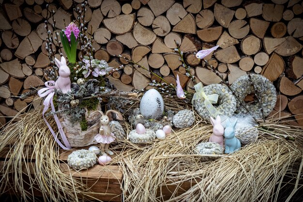 Composizione nel mazzo di Pasqua con uova colorate nel nido su fondo in legno