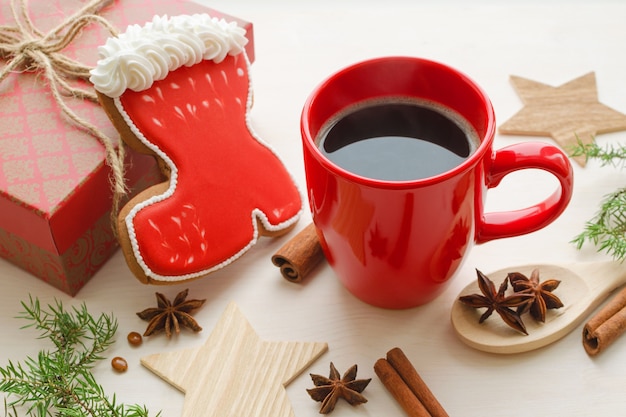 Composizione nel periodo natalizio con una tazza di caffè rossa e un biscotto di pan di zenzero