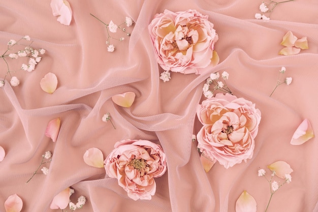 Composizione nuziale con pastello rosa tessuto di tulle delicato con petali di rose elementi decorativi per la celebrazione sfondo floreale romantico per una varietà di usi creativi design di decorazione