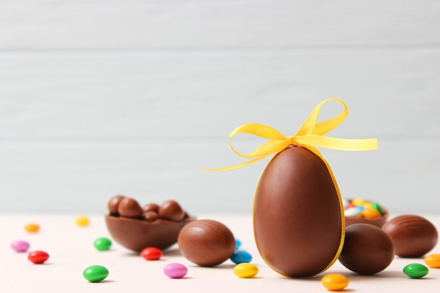 Composizione pasquale con uova di cioccolato e coniglio al cioccolato su fondo di legno