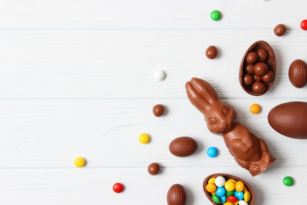 Composizione pasquale con uova di cioccolato e coniglio al cioccolato su fondo di legno