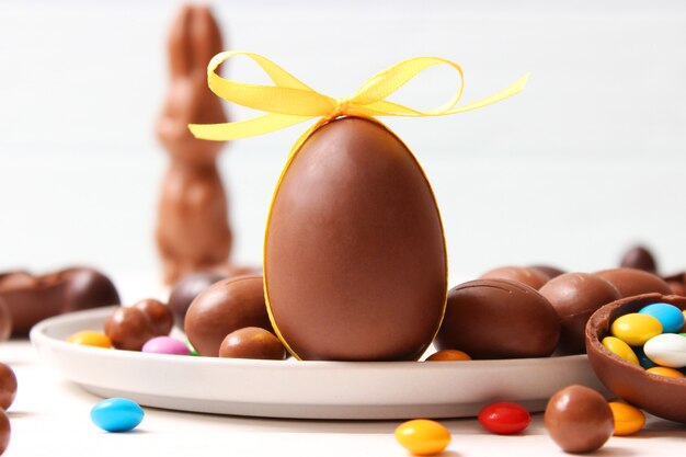 Composizione pasquale con uova di cioccolato e coniglio al cioccolato su fondo di legno