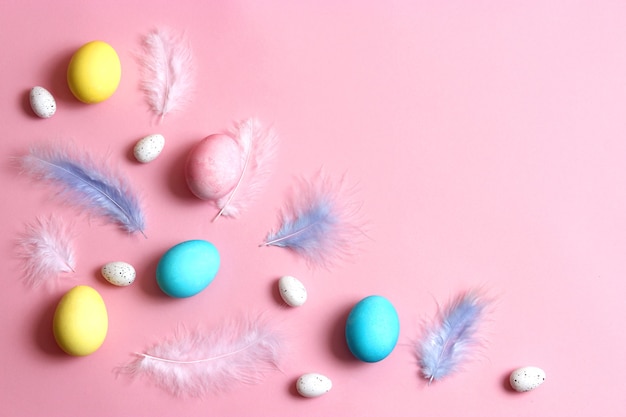 Composizione pasquale di uova e piume dipinte su uno sfondo colorato