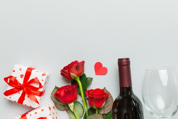 Composizione per il giorno di San Valentino con vino rosso fiore di rosa e scatola regalo sul tavolo Vista superiore piana concepimento di vacanza