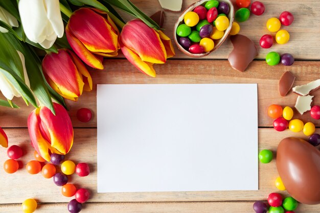 Composizione per le vacanze di Pasqua fatta di uova di cioccolato, dolci e tulipani