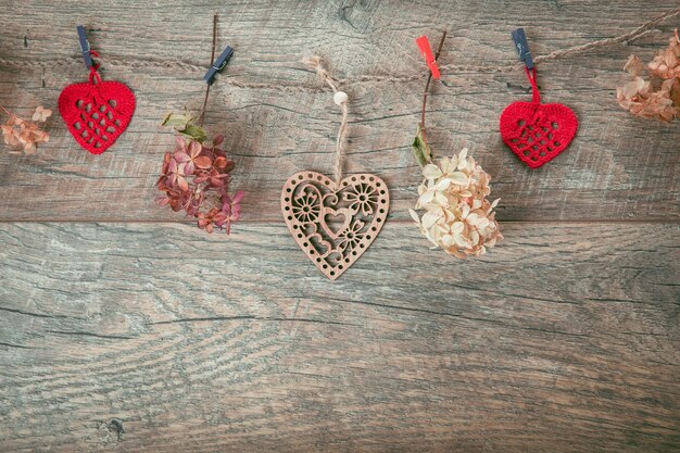 Composizione per le vacanze di San Valentino, ornamento. Modello creativo festivo, cuori fatti a mano e nastro su fondo di legno marrone. Vista piana e dall'alto. Concetto di compleanno, mamma, donna, giorno del matrimonio.