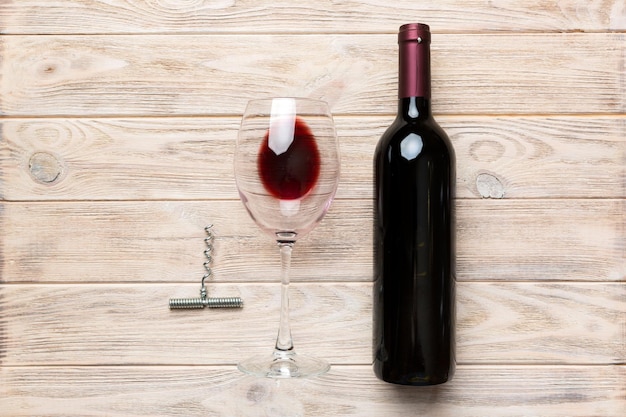 Composizione piatta con bottiglia di vino a cavatappi e vetro elegante su tavolo colorato Vista dall'alto piatta con spazio per la copia