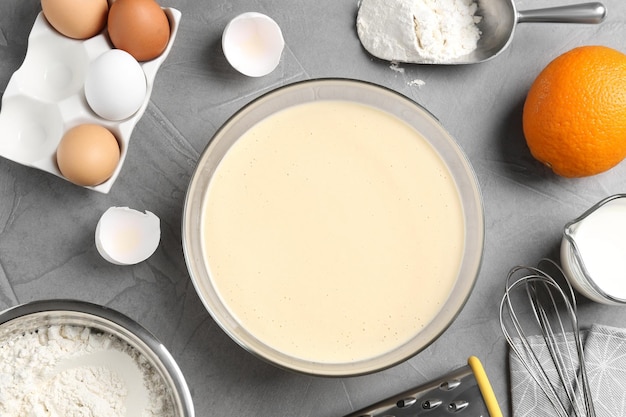 Composizione piatta con pastella e ingredienti sul tavolo grigio