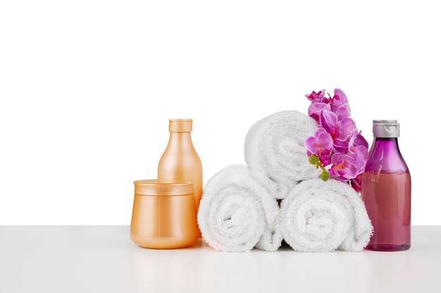 Composizione spa con asciugamani e fiori isolati su bianco