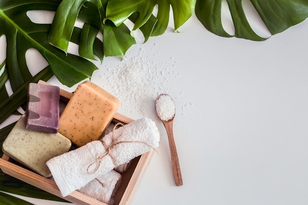 Composizione Spa con foglie tropicali su sfondo bianco. Diverso concetto di sapone organico, cura e bellezza, vista dall'alto