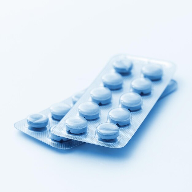 Compresse pillole imballaggio farmacia medicina medica su sfondo bianco blu