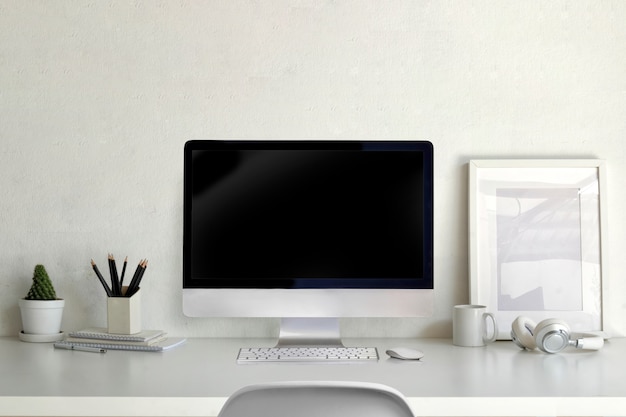 Computer desktop di modello con telaio vuoto poster e forniture per ufficio sul tavolo dell&#39;area di lavoro