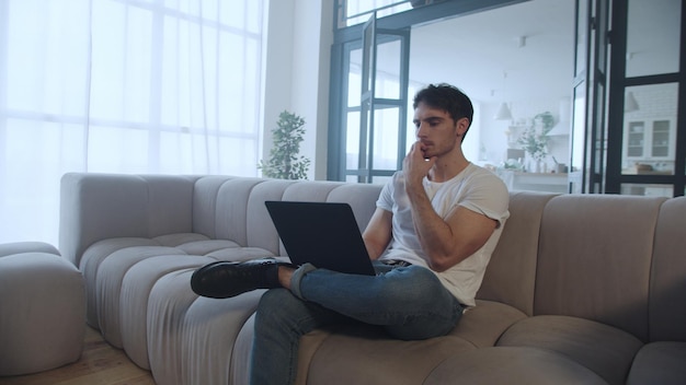 Computer di lavoro dell'uomo concentrato sul posto di lavoro remoto al rallentatore