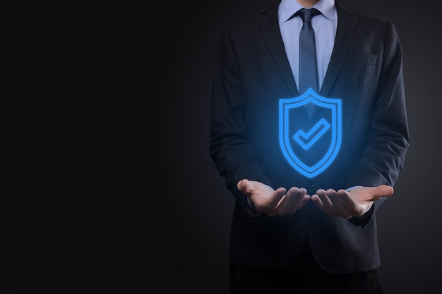 Computer di sicurezza di rete di protezione nelle mani di un uomo d'affari. affari, tecnologia, sicurezza informatica e concetto di internet - uomo d'affari premendo il pulsante scudo su schermi virtuali Protezione dei dati.