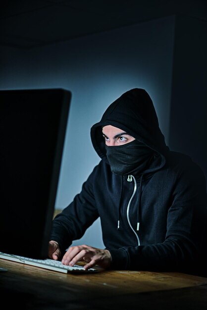 Computer e cappuccino su sfondo nero per l'hacking, il phishing e il malware con virus, tecnologia e software per il cybercrime, hacktivismo o spionaggio dell'informazione con programmazione o codifica