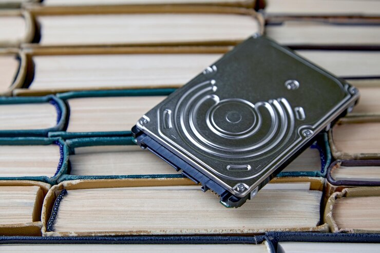 Photo computer hard drive on the background of a stack of old paper books