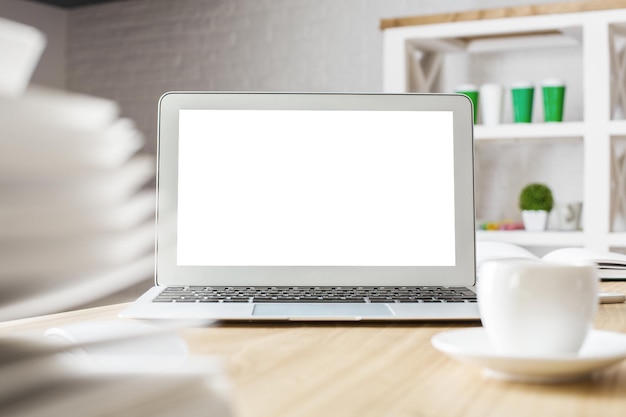 Computer portatile bianco e tazza di caffè