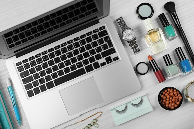 Computer portatile con accessori da donna su sfondo tavolo in legno bianco