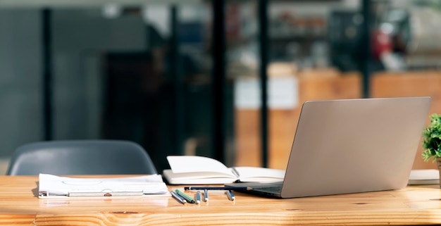 Computer portatile con coperchio aperto sul tavolo nella moderna stanza dell'ufficio. Concetto di sfondo dell'area di lavoro creativa.