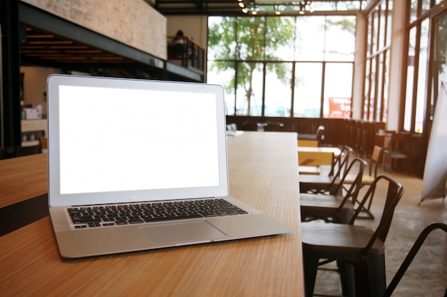 Computer portatile con Mock up schermo vuoto sul tavolo di legno di fronte al caffè cafè spazio per il testo. concetto di montage-technology
