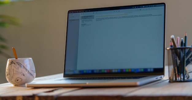 Computer portatile con schermo in bianco nero su una scrivania di legno