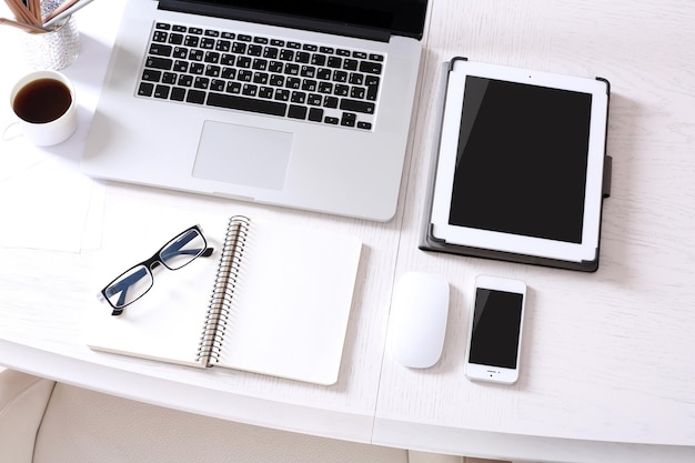 Computer portatile con tablet e smartphone nella vista dall'alto sul posto di lavoro