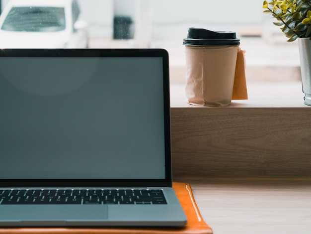 Computer portatile con una tazza di caffè caldo sulla barra del caffè.